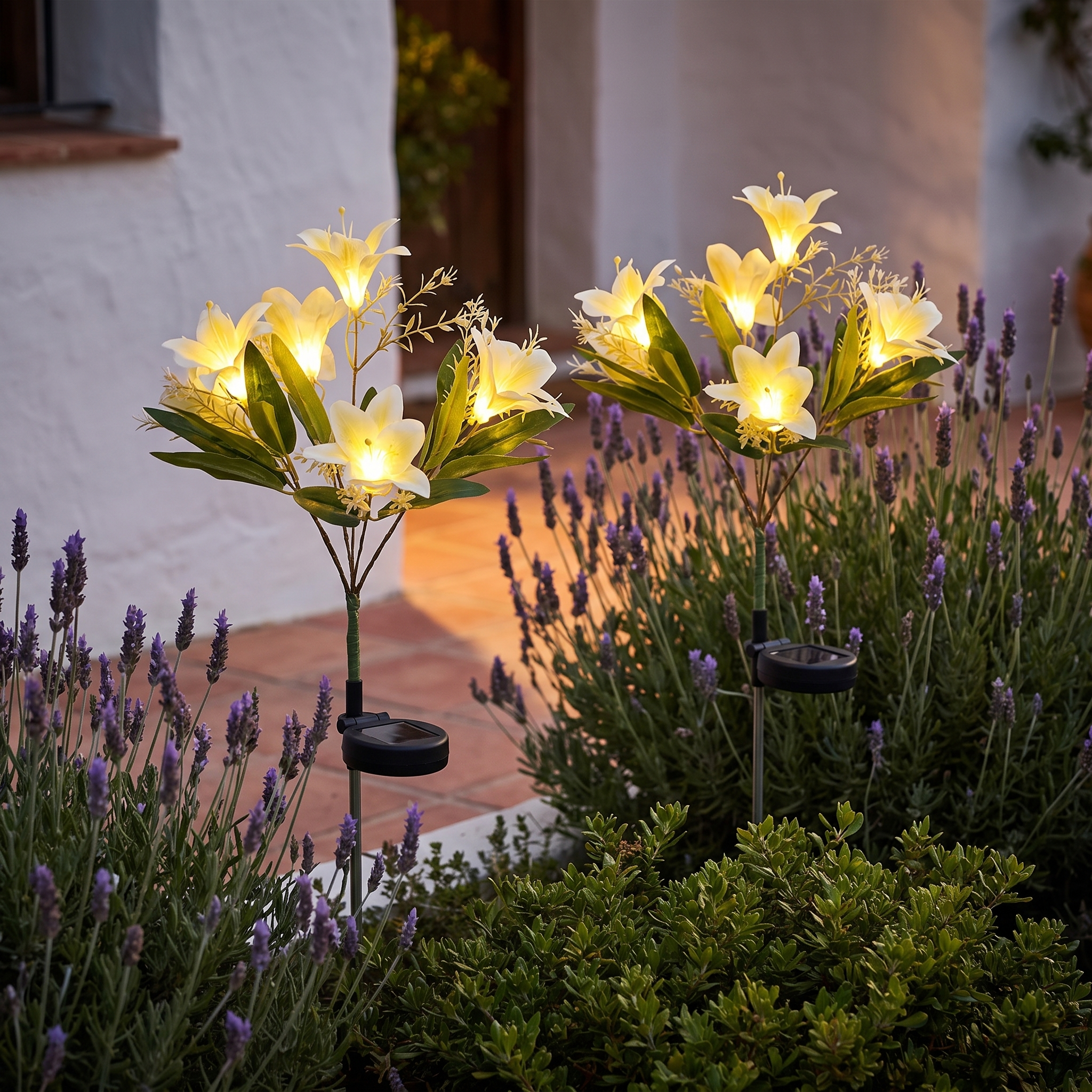 Set de 2 lamparas solares de lirios blancos encendidas en un jardin